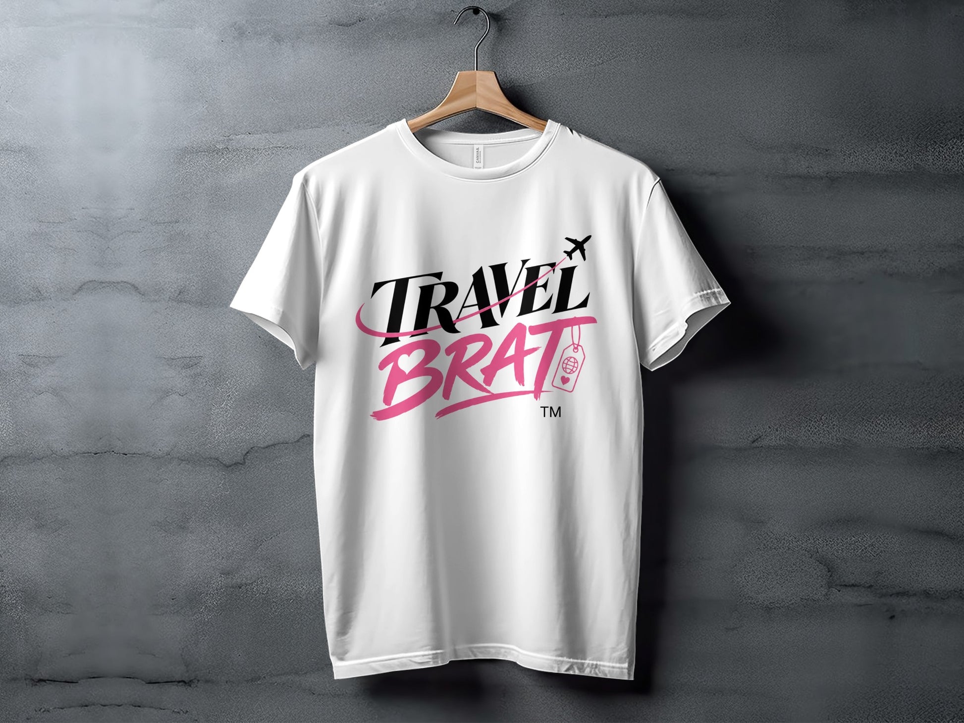 White t-shirt with "TRAVEL BRAT" text, airplane, and suitcase graphic.