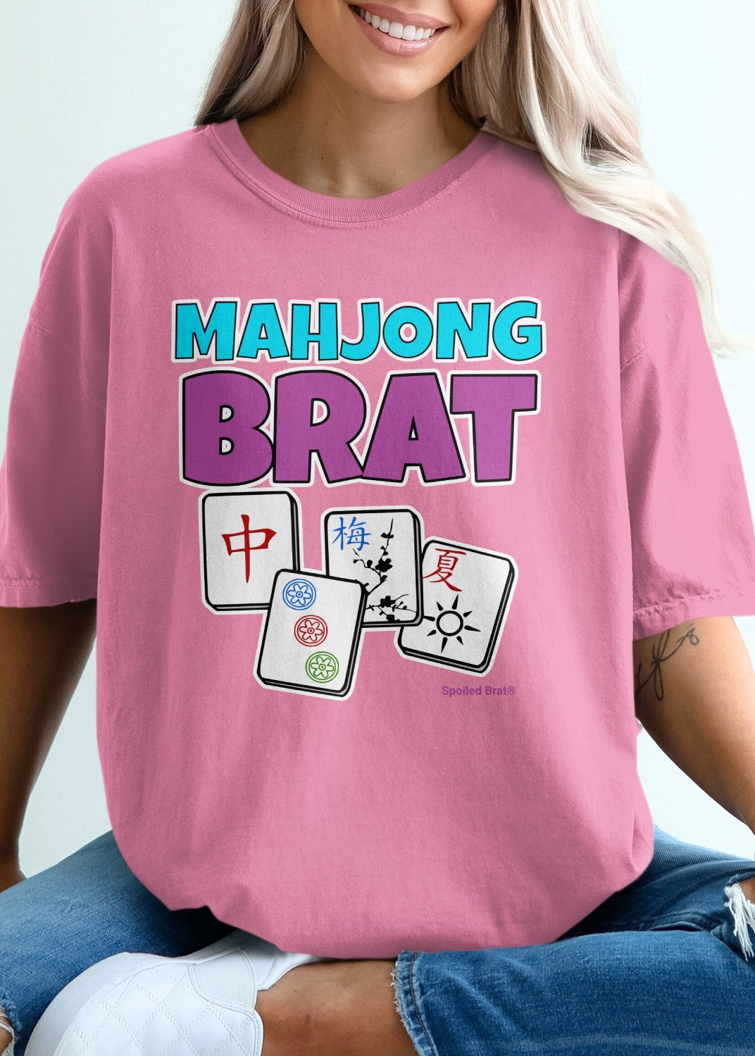 Mahjong Brat text on pink t-shirt with three Mahjong tiles.