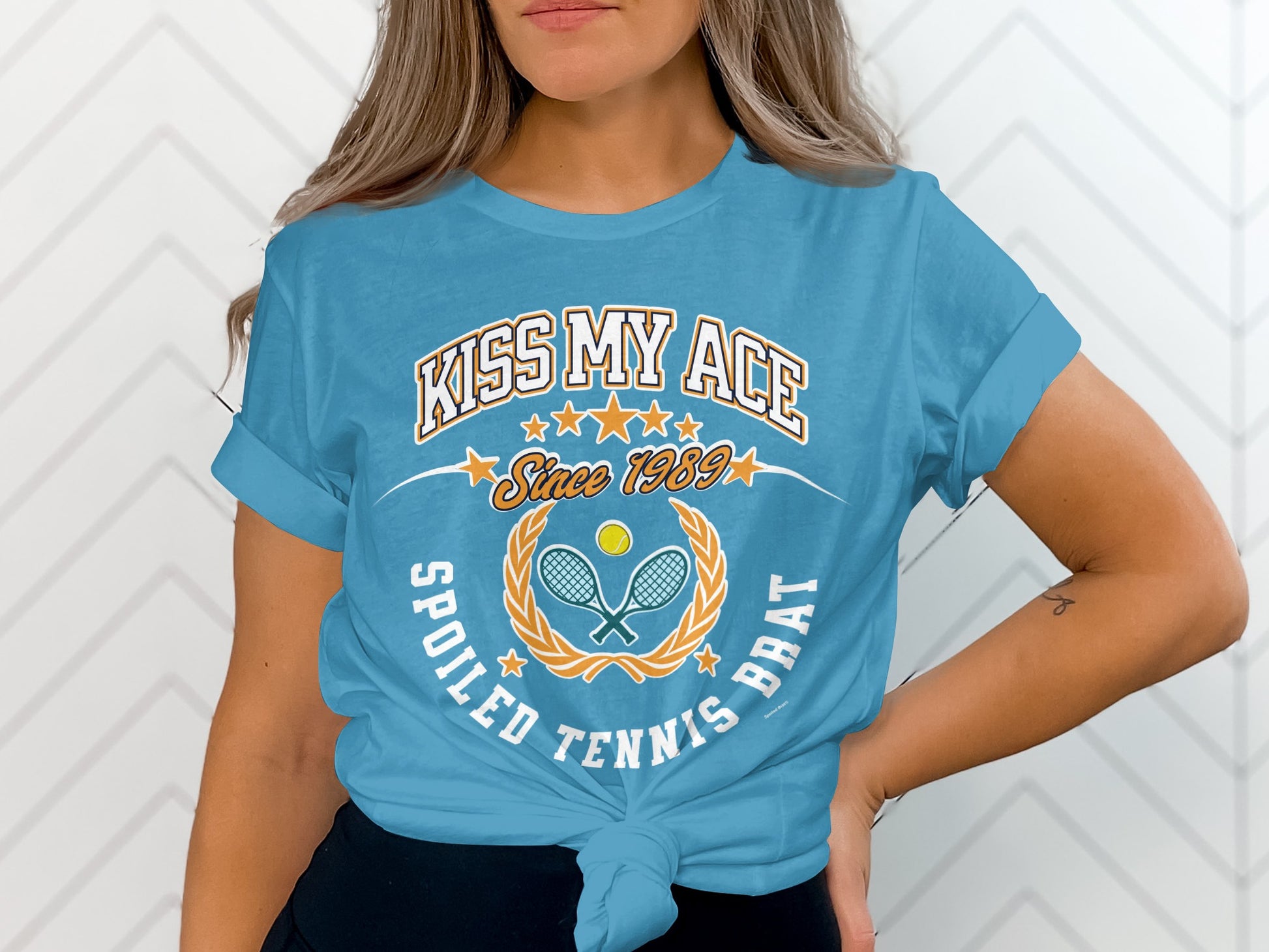 Blue t-shirt with "Kiss My Ace" and tennis imagery, text "Spoiled Tennis Brat".