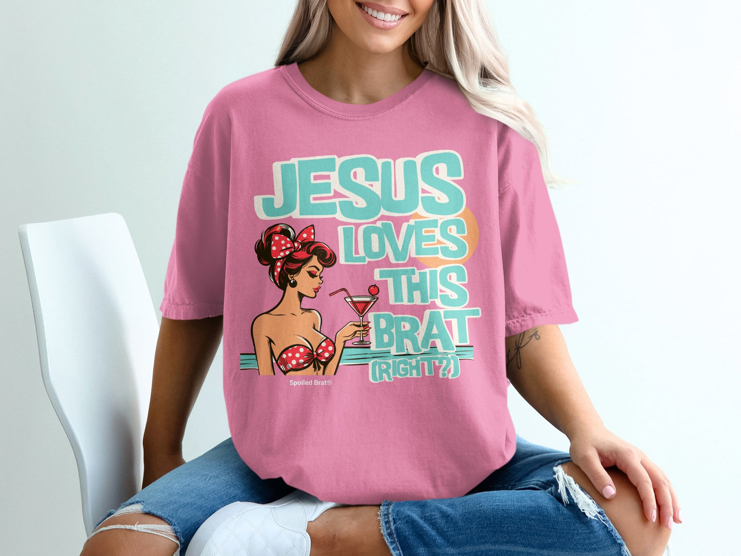 Pink t-shirt with "JESUS LOVES THIS BRAT (RIGHT?)" and pin-up girl graphic.