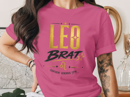 Pink t-shirt with gold "LEO BRAT" text and horoscope symbols.