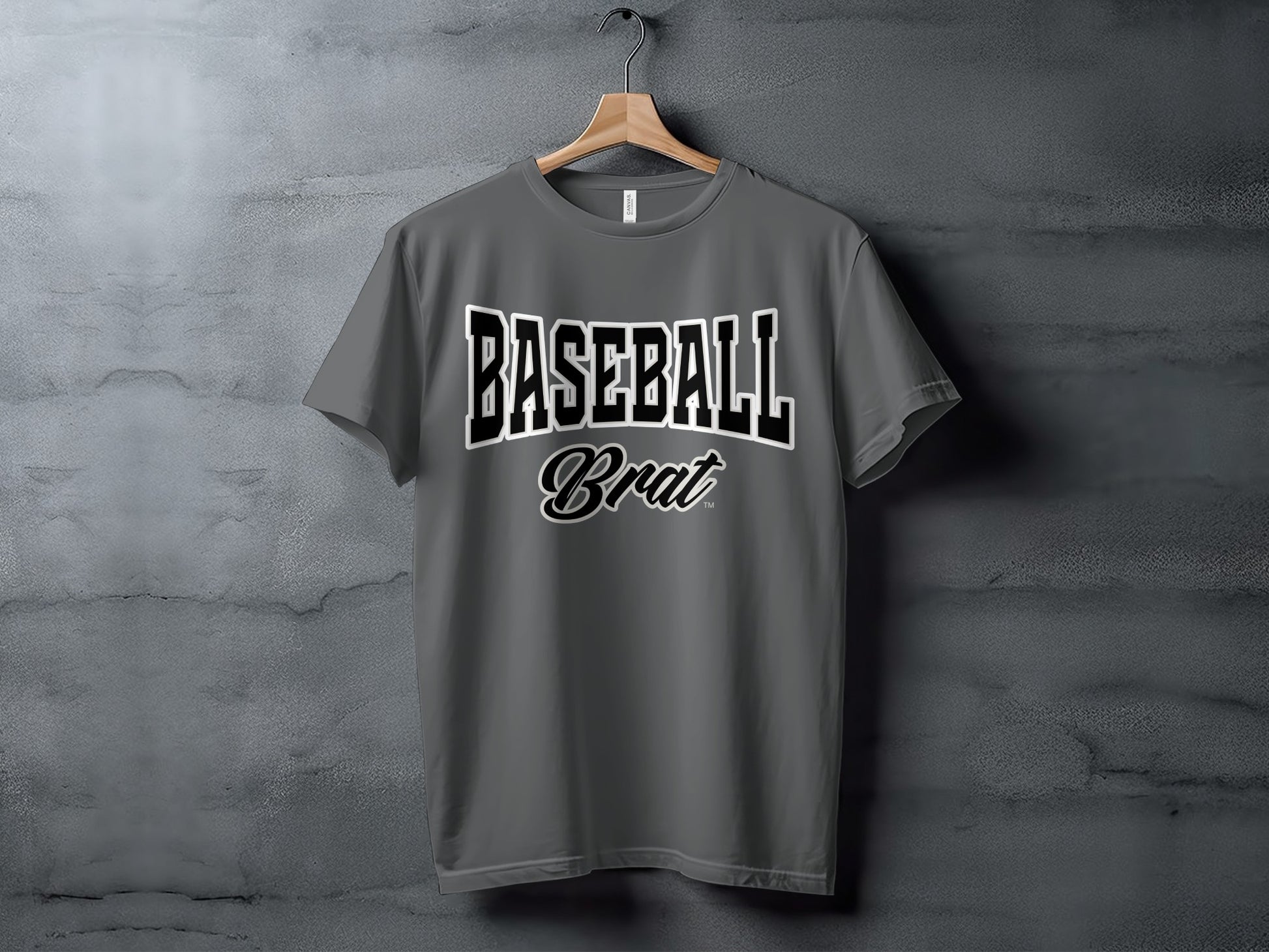 Gray t-shirt with "BASEBALL Brat" graphic on a concrete background.