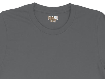 Grey t-shirt neckline with "PIANO BRAT" logo in orange and white.