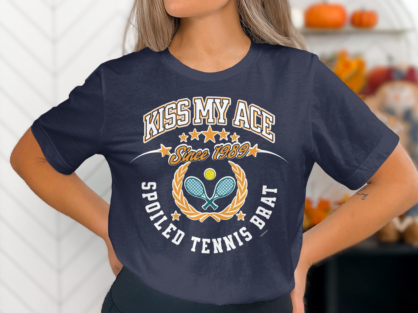 Navy t-shirt with "Kiss My Ace Spoiled Tennis Brat" text and tennis graphic.