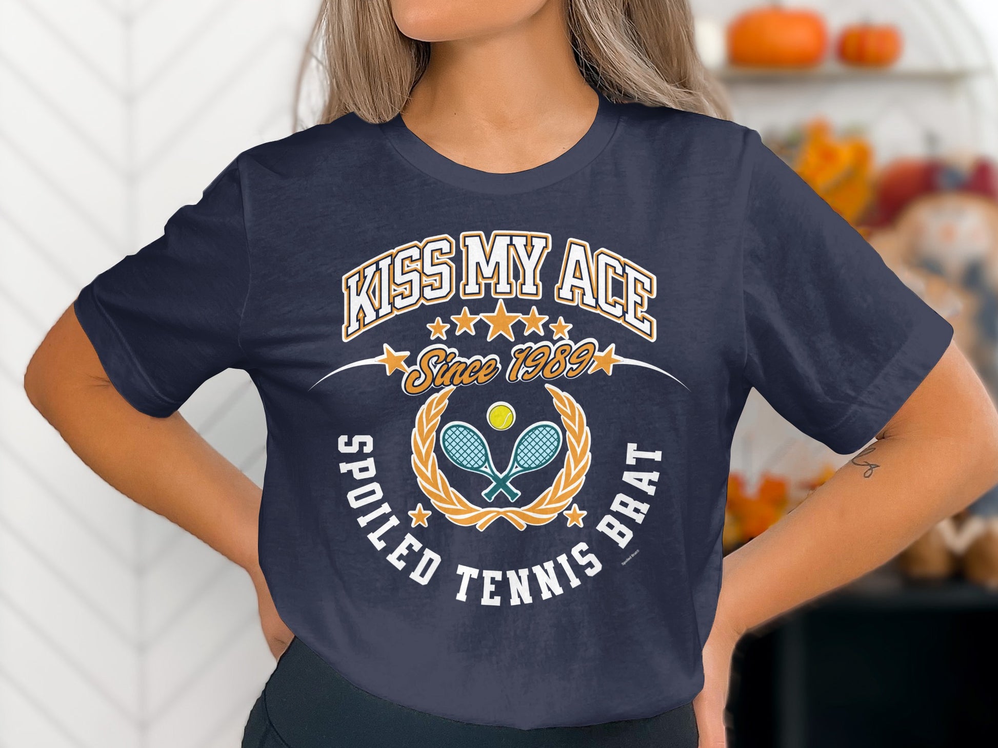 Navy t-shirt with "Kiss My Ace Spoiled Tennis Brat" text and tennis graphic.
