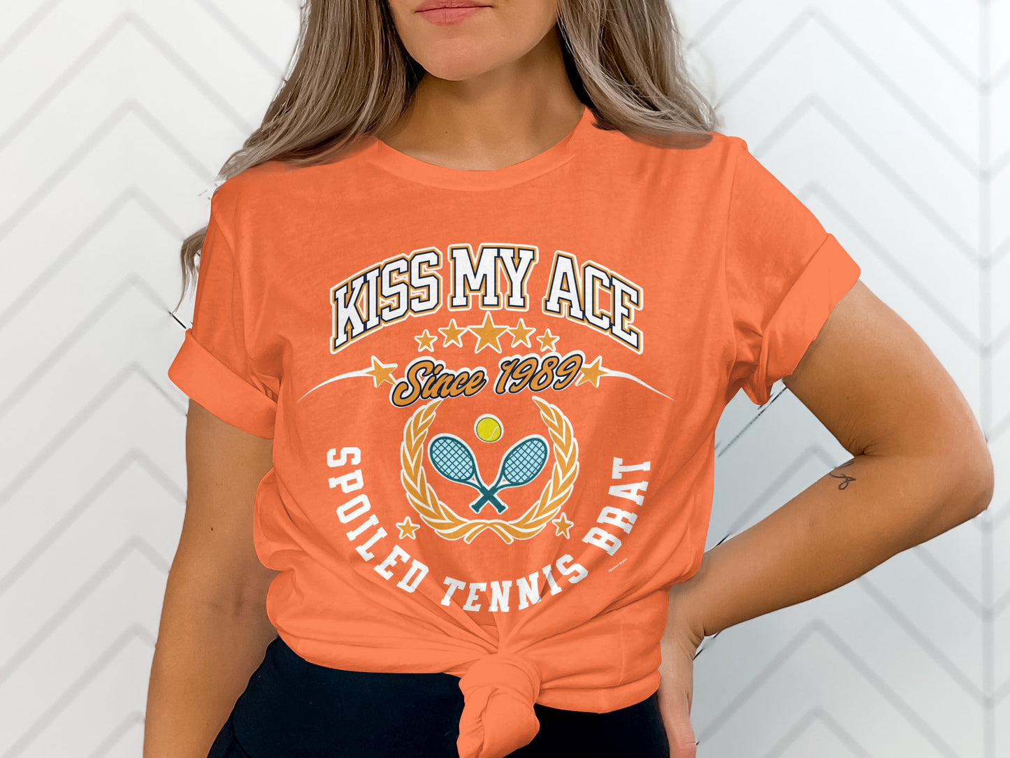 Orange t-shirt with "Kiss My Ace" and tennis graphics, "Spoiled Tennis Brat".