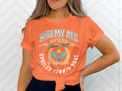 Orange t-shirt with "Kiss My Ace" and tennis graphics, "Spoiled Tennis Brat".