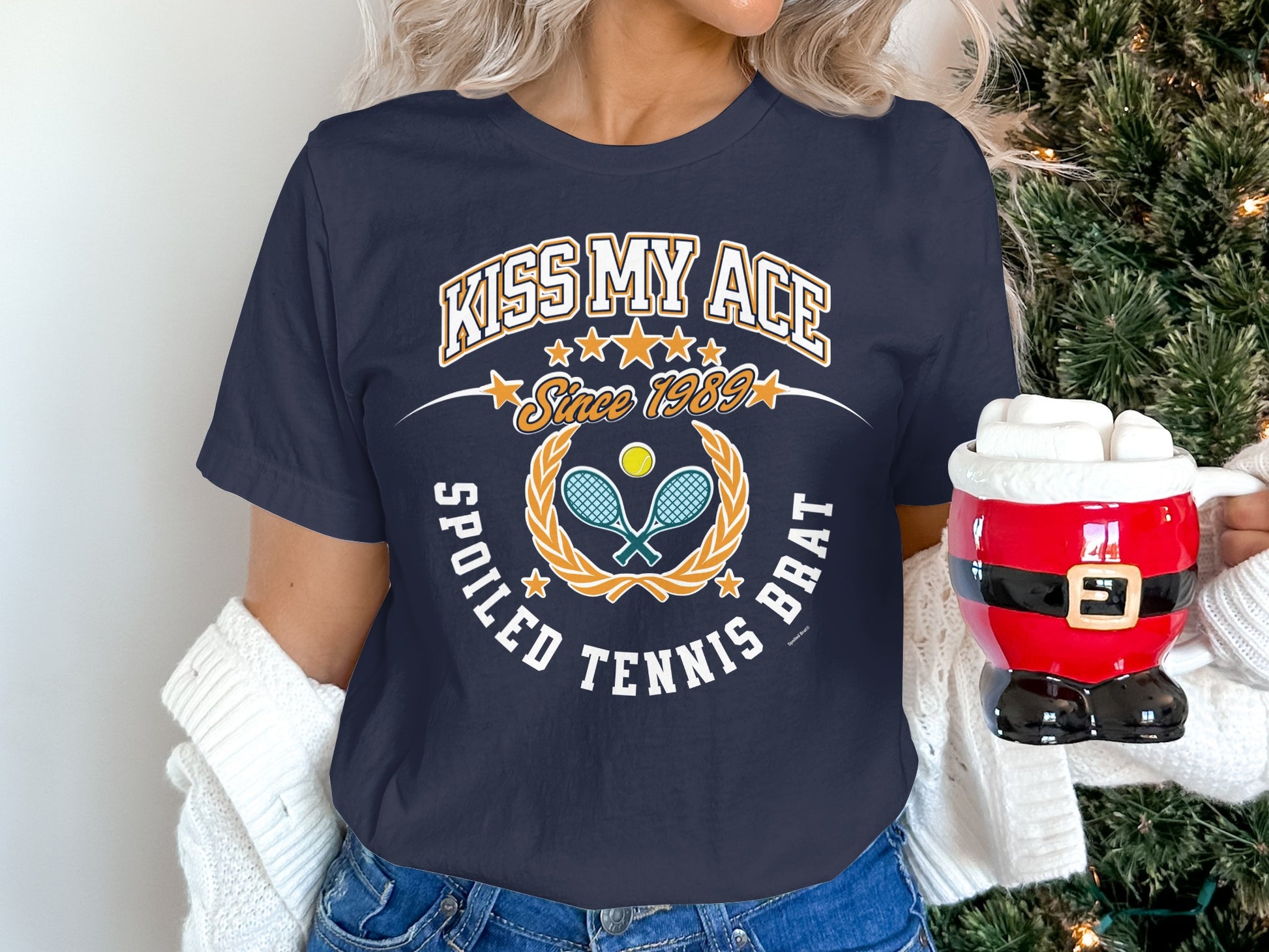 Navy t-shirt with "Kiss My Ace Spoiled Tennis Brat" text and tennis rackets.