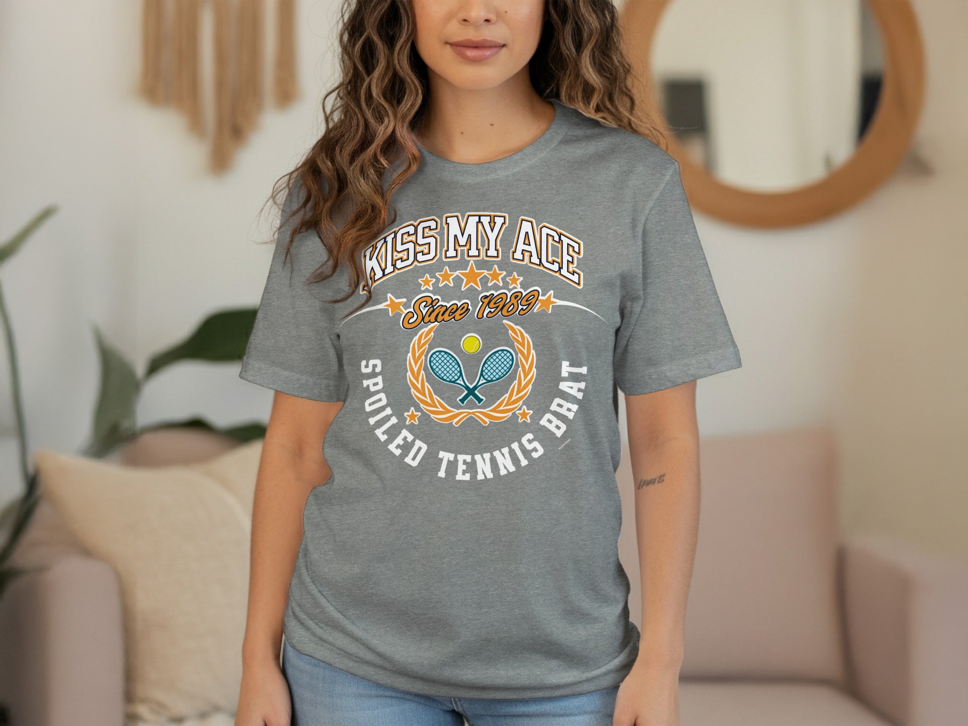Grey t-shirt with "Kiss My Ace Spoiled Tennis Brat Since 1989" text and tennis graphics.