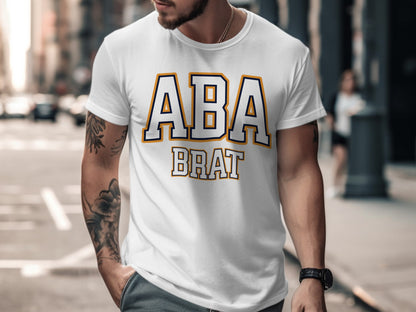 White t-shirt with navy and orange ABA BRAT text in varsity font.