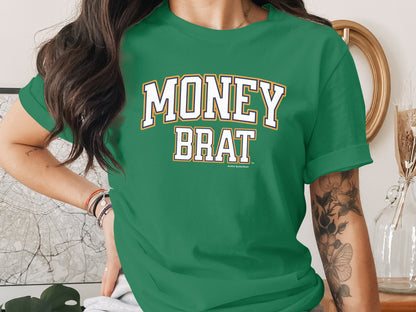 Green t-shirt with "MONEY BRAT" text in white and gold block letters.