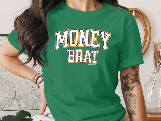 Green t-shirt with "MONEY BRAT" text in white and gold block letters.