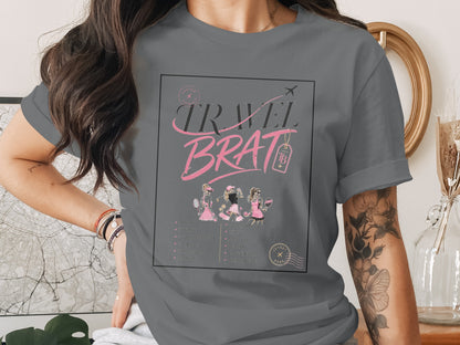 Grey t-shirt with "TRAVEL BRAT" graphic, three figures, and city list.