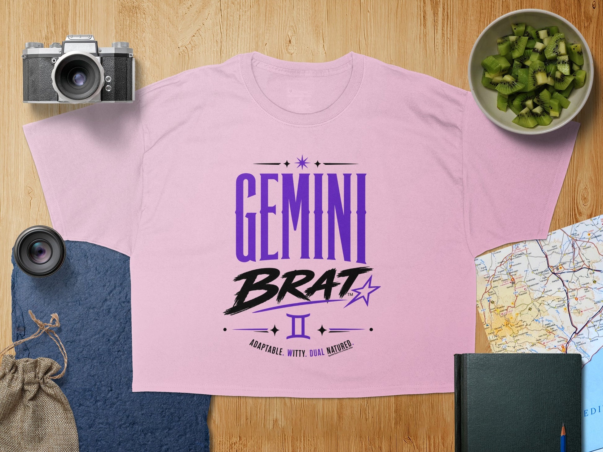 Pink t-shirt with "Gemini Brat" and zodiac symbol with "Adaptable. Witty. Dual Natured." text.