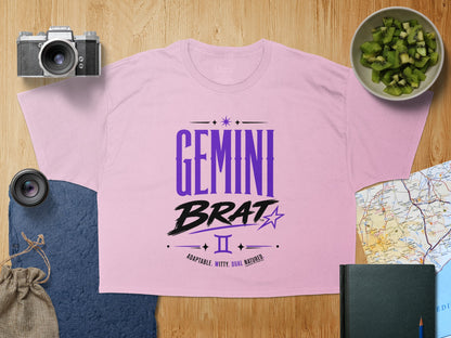 Pink t-shirt with "Gemini Brat" and zodiac symbol with "Adaptable. Witty. Dual Natured." text.
