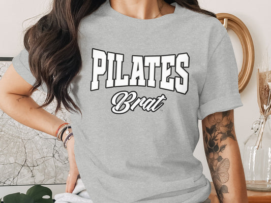 Grey t-shirt with "PILATES Brat" graphic text.