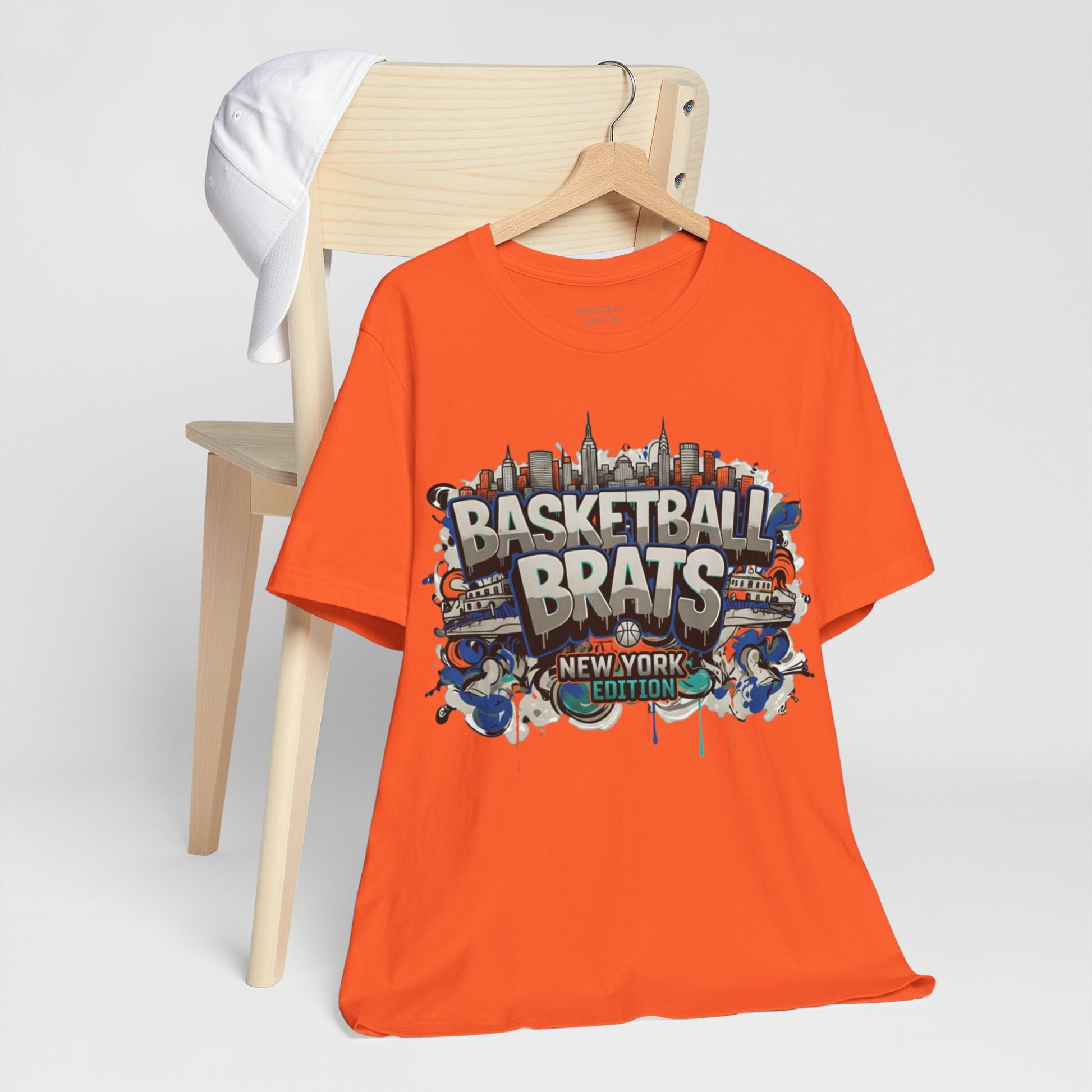 Orange t-shirt with "Basketball Brats New York Edition" graffiti graphic.