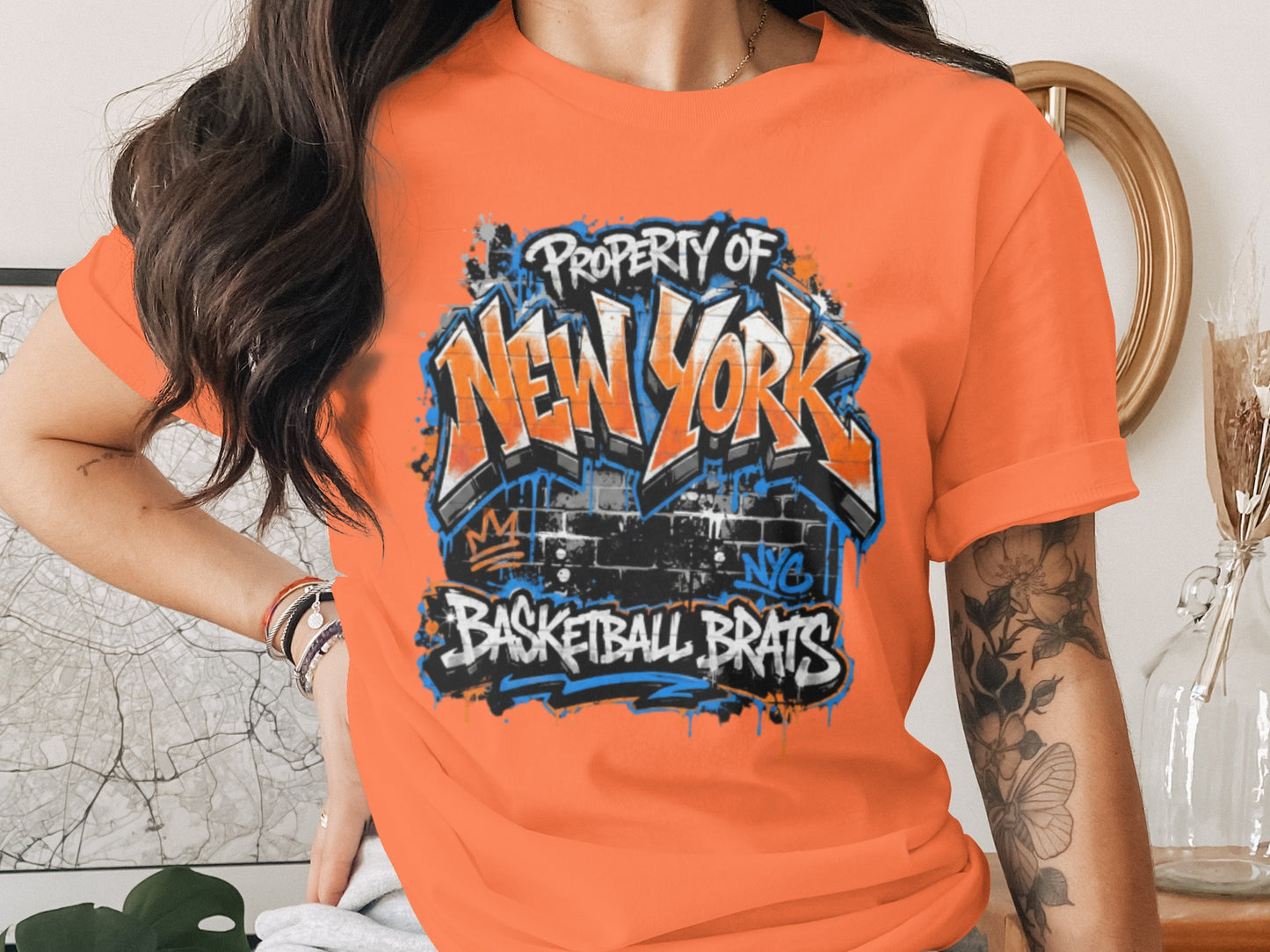 Orange t-shirt with graffiti-style "Property of New York Basketball Brats" text.
