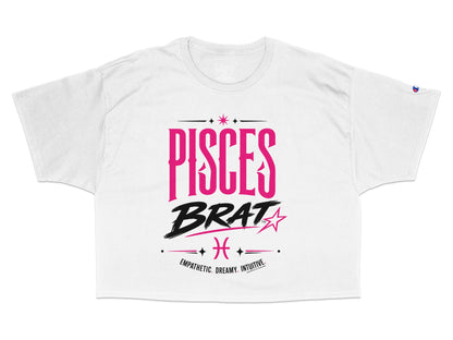 White cropped t-shirt with "PISCES BRAT" text, Pisces symbol, and descriptive words.
