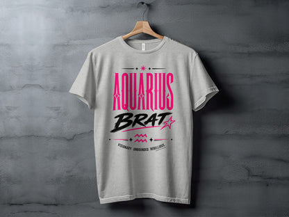 Grey t-shirt with "AQUARIUS BRAT VISIONARY. UNBOUNDED. REBELLIOUS." printed in pink.