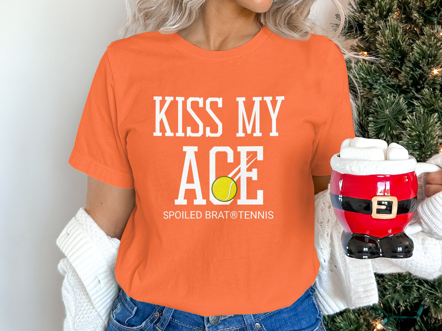 Orange t-shirt with "Kiss My Ace Spoiled Brat Tennis" and tennis ball graphic.