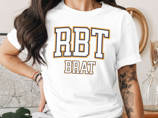White t-shirt with navy and gold text that reads "RBT BRAT".