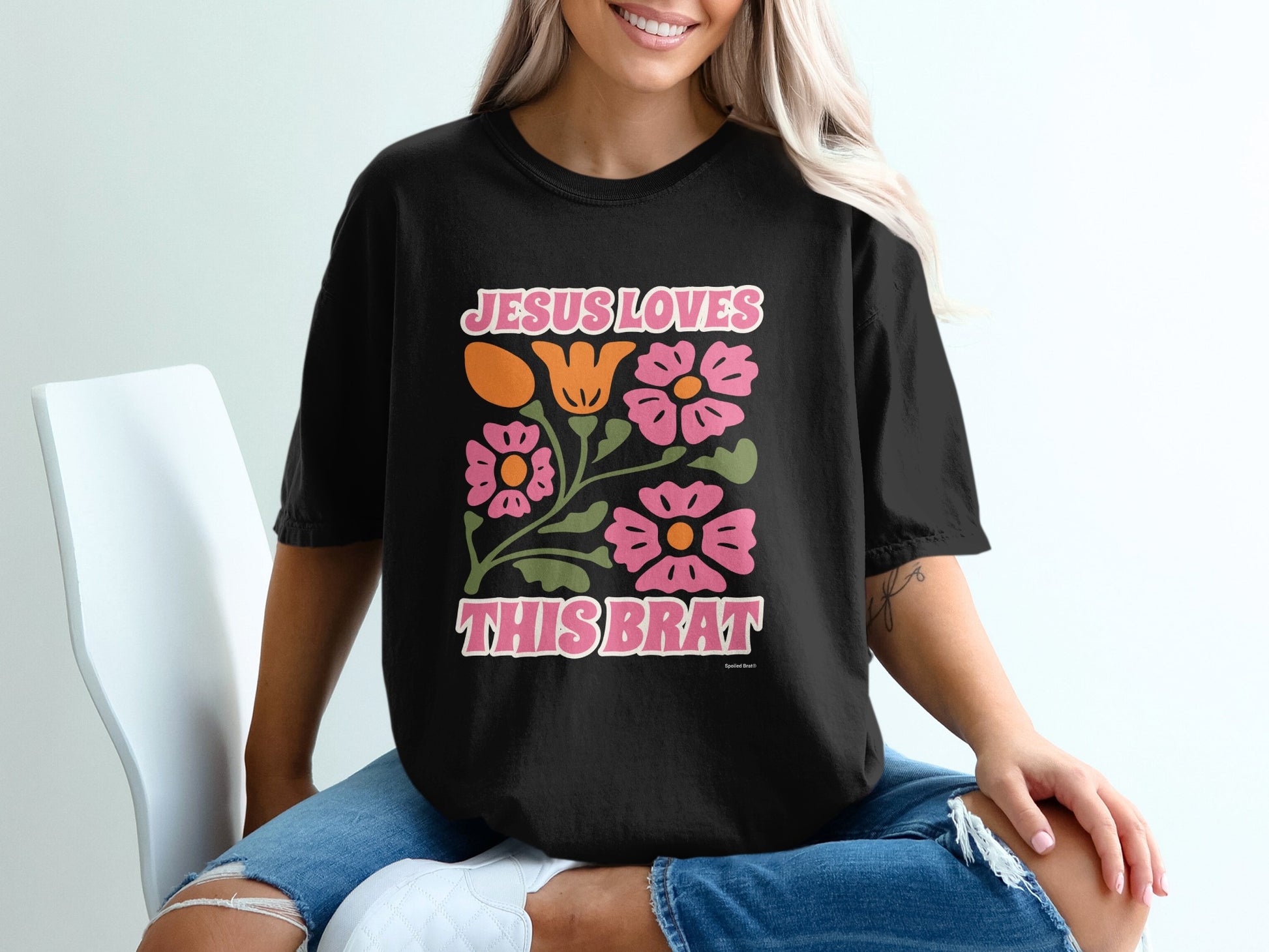 Black t-shirt with "Jesus Loves This Brat" and floral design.
