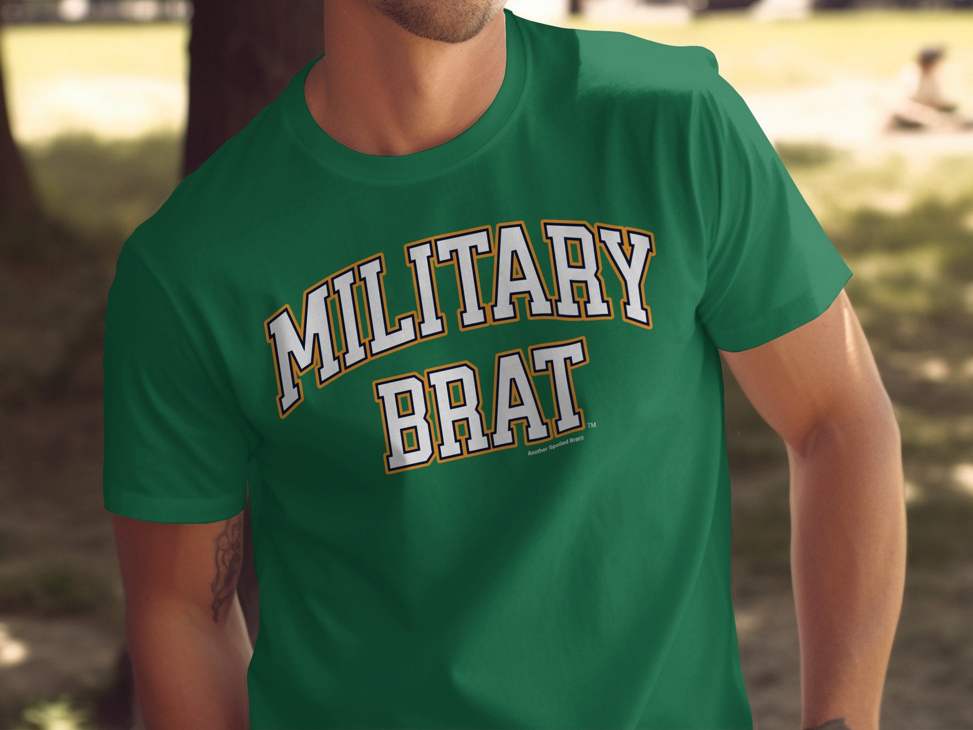 Green t-shirt with white "MILITARY BRAT" text in arched lettering.
