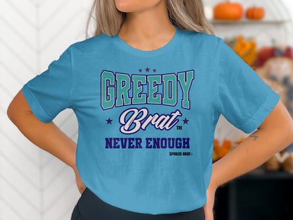 Teal t-shirt with "Greedy Brat Never Enough" text and stars.