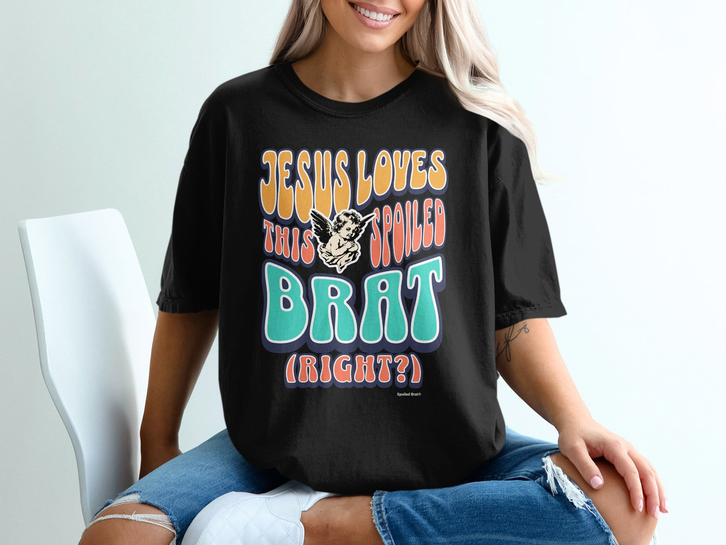 Black t-shirt with "Jesus Loves This Spoiled Brat" text and angel graphic.