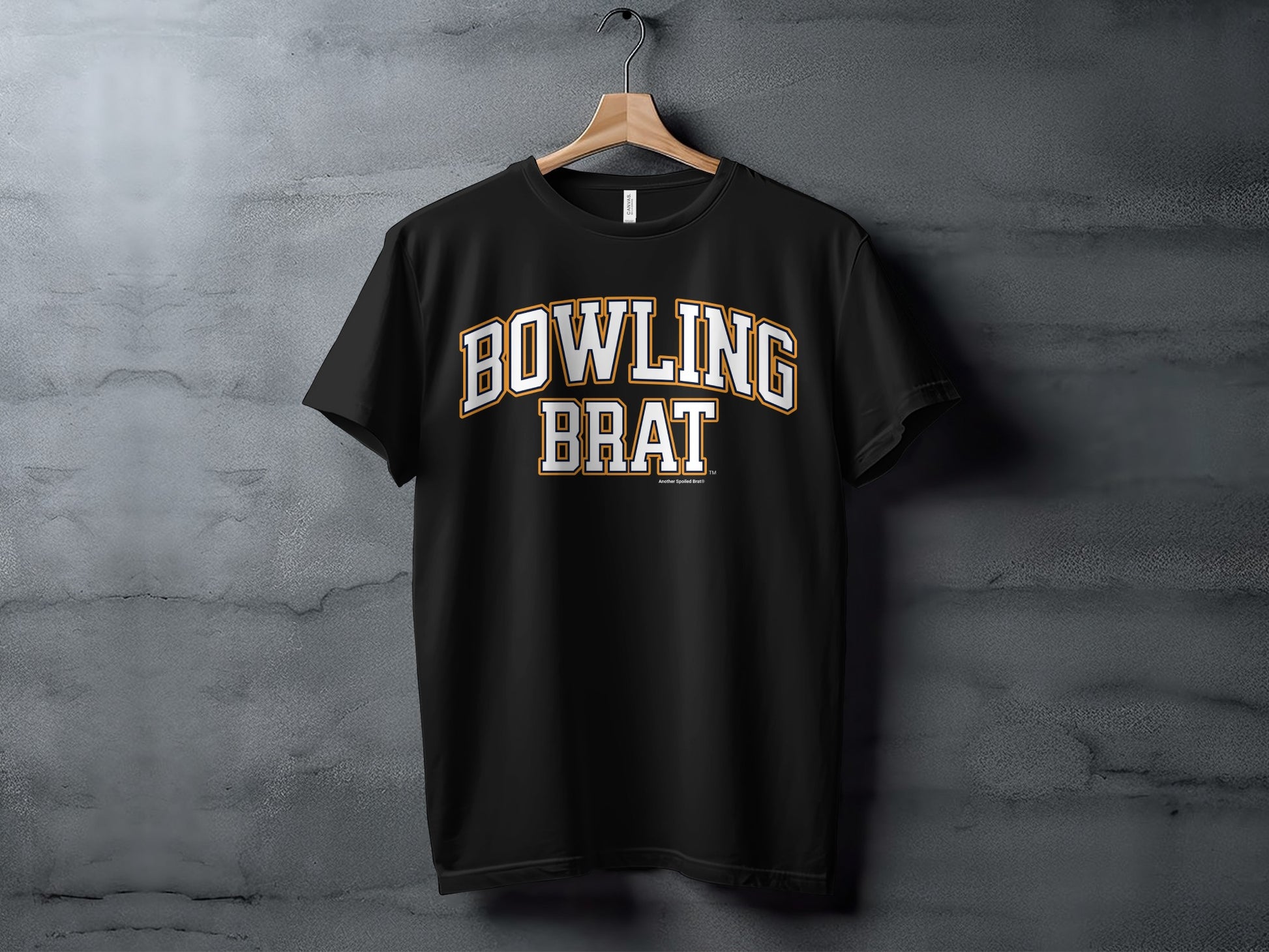 Black t-shirt with white and orange arched text reading "BOWLING BRAT".