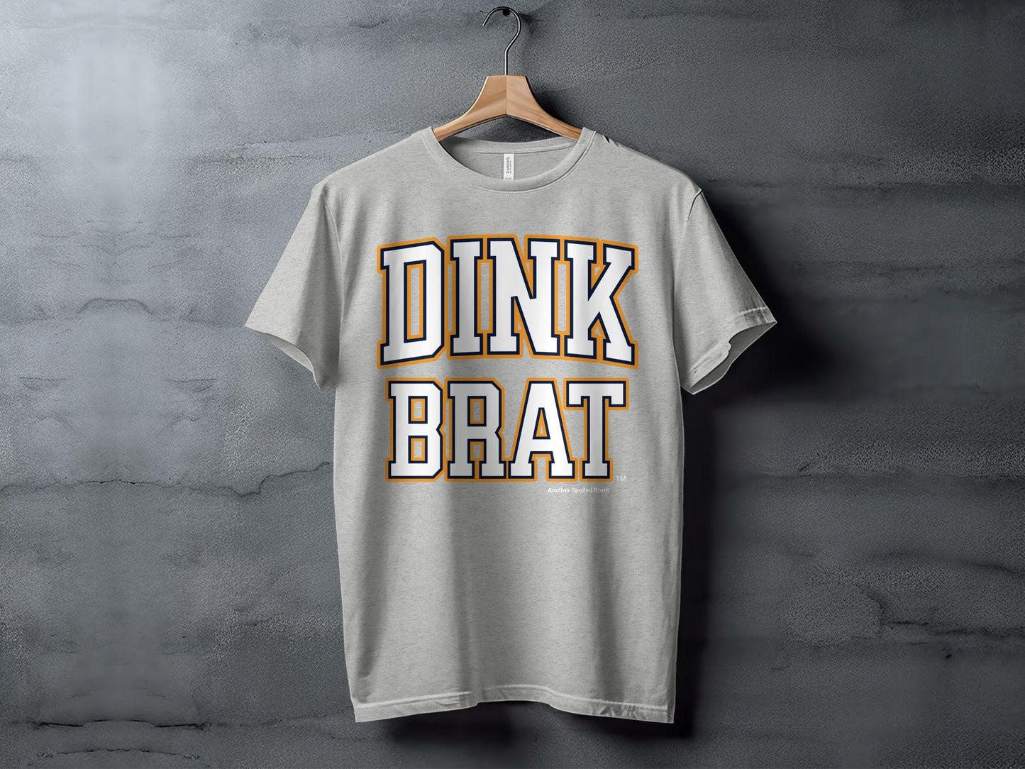 Grey t-shirt with white and orange text reading "DINK BRAT"