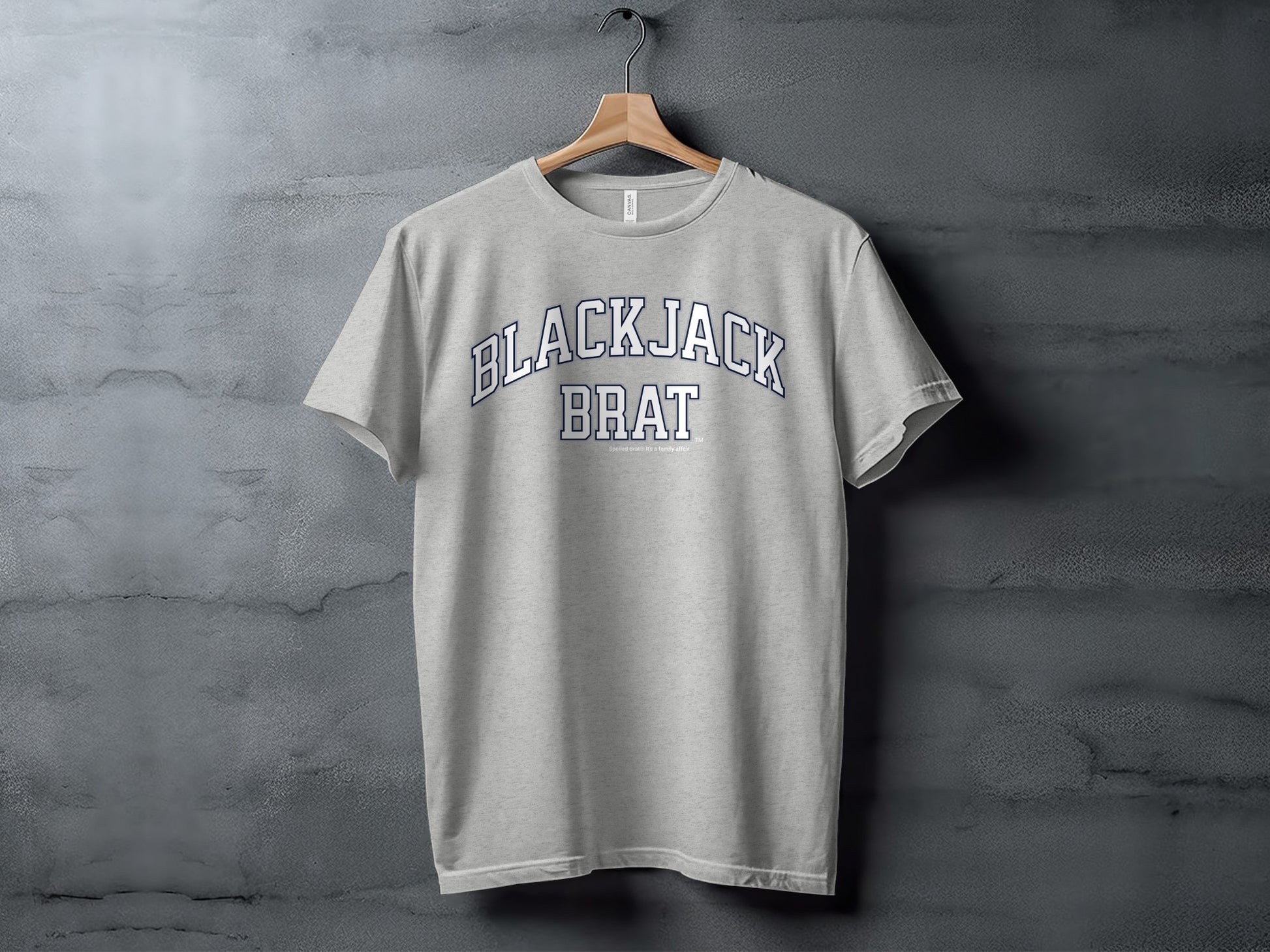 Grey t-shirt with navy blue arch text "BLACKJACK BRAT" displayed across the chest.