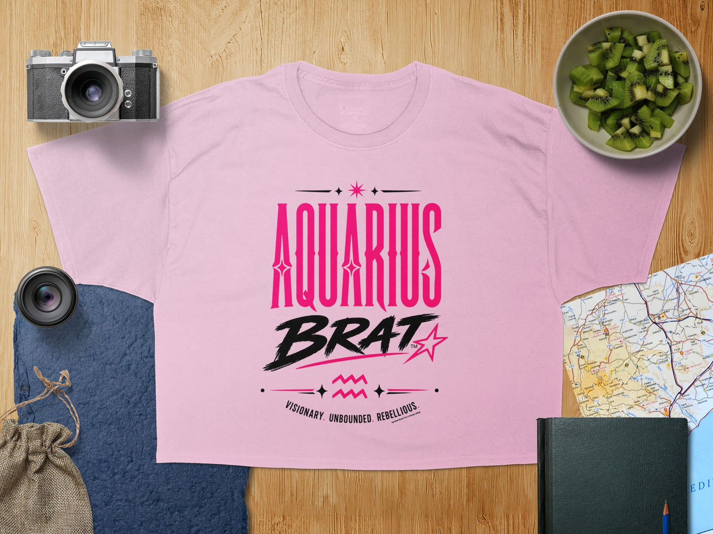 Pink t-shirt with "AQUARIUS BRAT" and "VISIONARY. UNBOUNDED. REBELLIOUS." text.