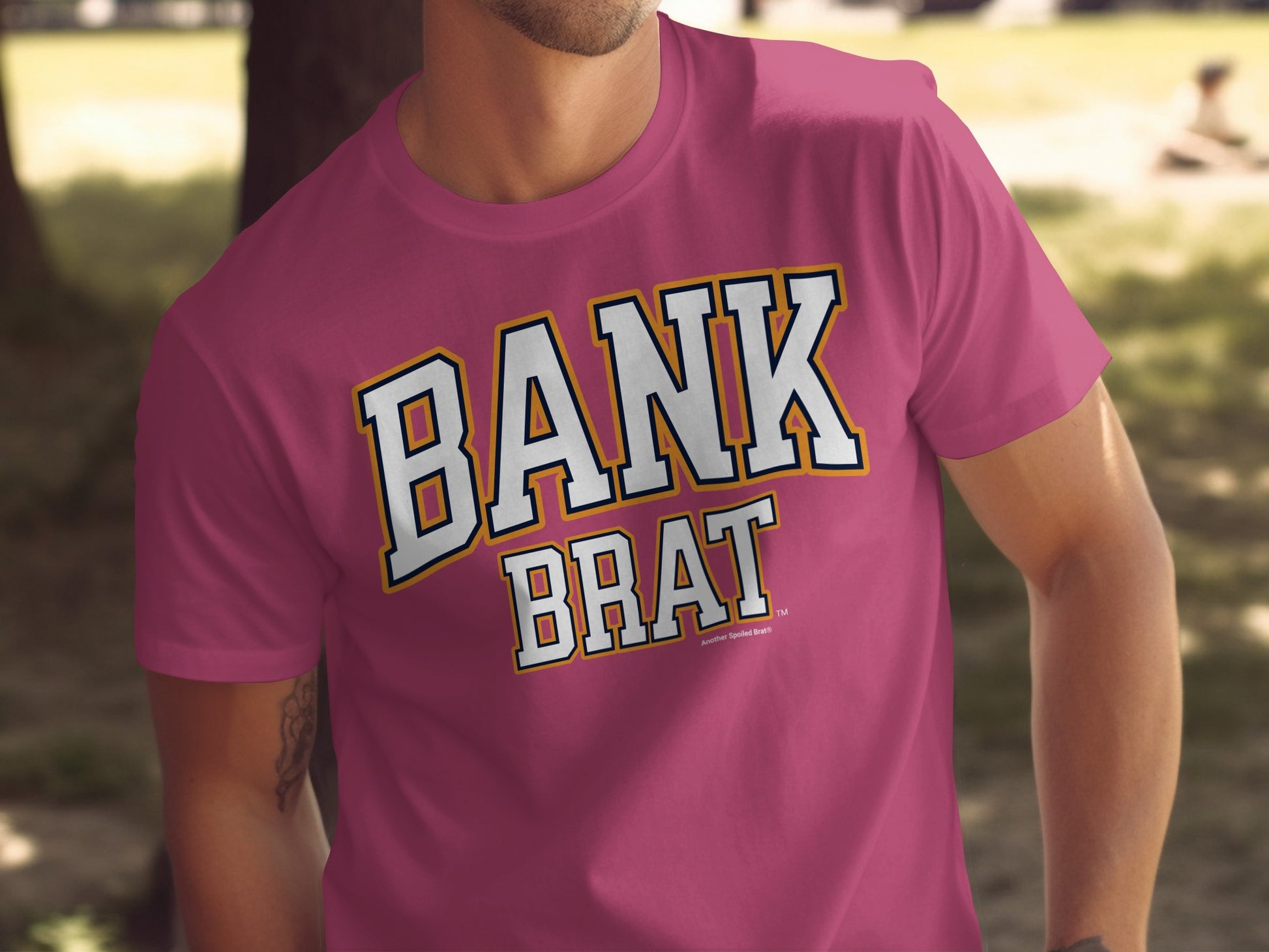 Pink t-shirt with "BANK BRAT" text in white with yellow and navy trim.