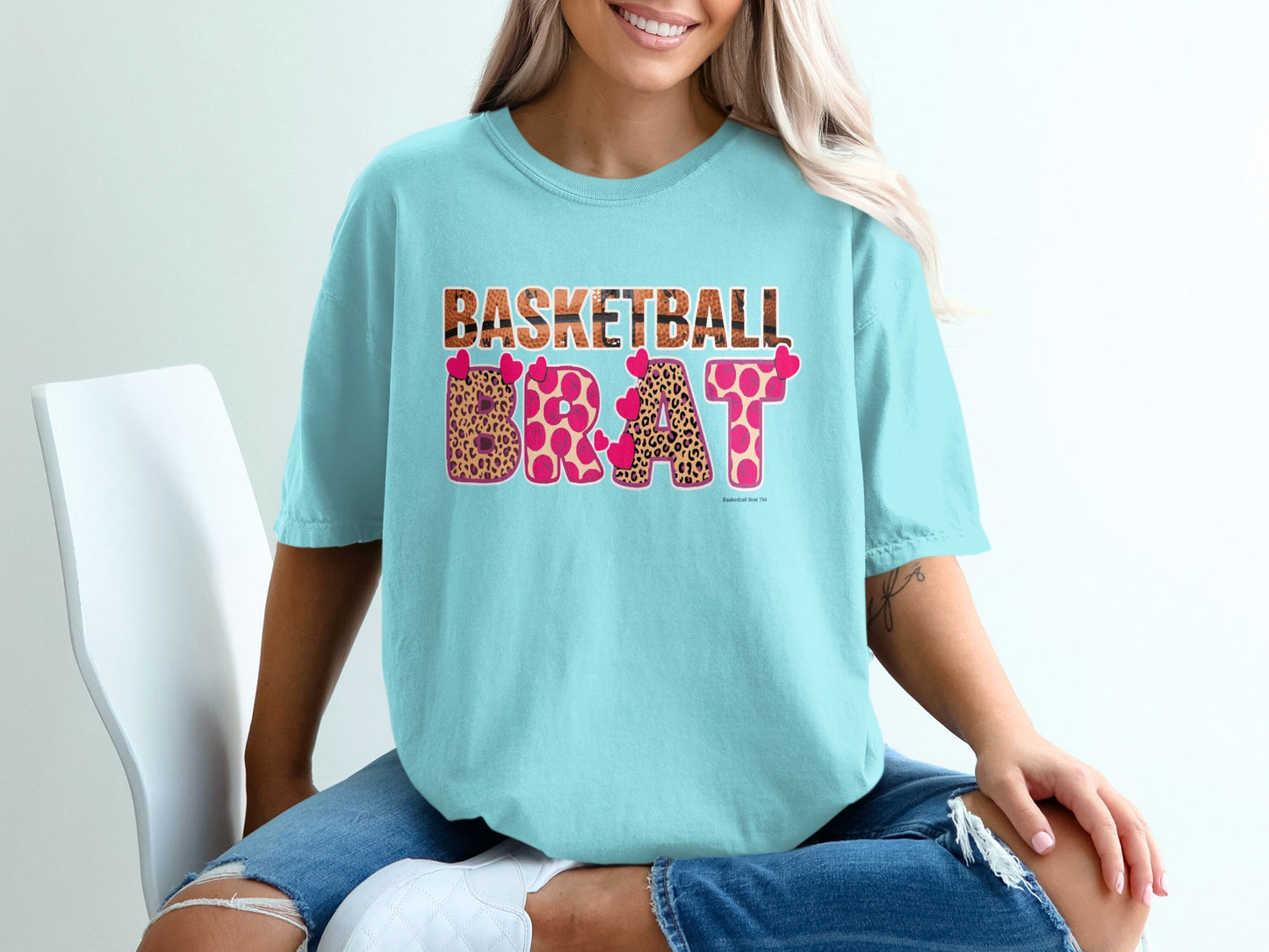 Light blue t-shirt with "BASKETBALL BRAT" in leopard print and pink hearts.