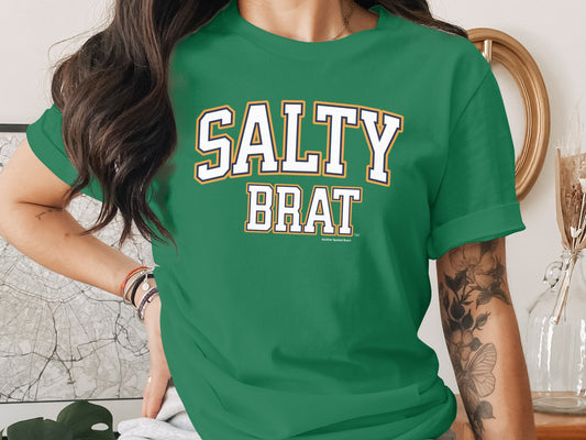 Green t-shirt with "SALTY BRAT" text in white with orange and navy outline.