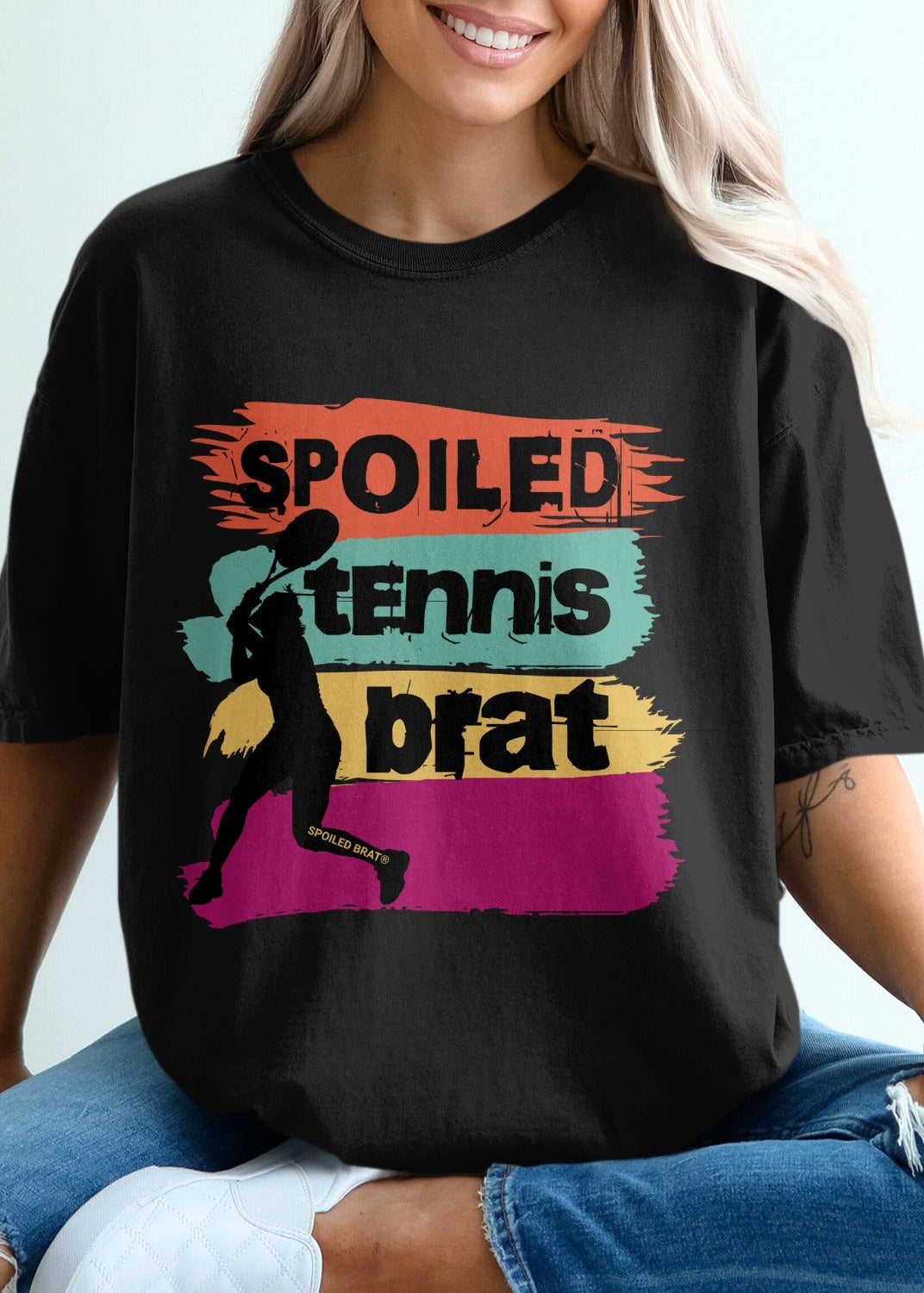 Black t-shirt with "SPOILED TENNIS BRAT" in colorful distressed text and a silhouette.