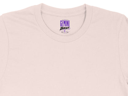 Light pink t-shirt with "Gemini Brat" graphic and astrological symbol.