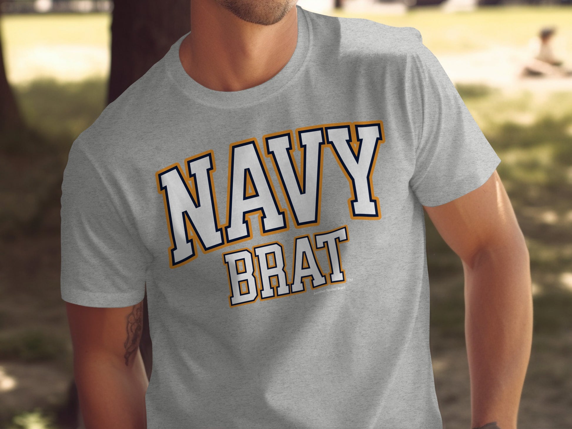 Grey t-shirt with "NAVY BRAT" text in white, navy, and orange lettering.