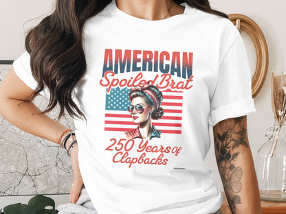 T-shirt graphic "AMERICAN SPOILED BRAT 250 Years of Clapbacks" with patriotic woman.