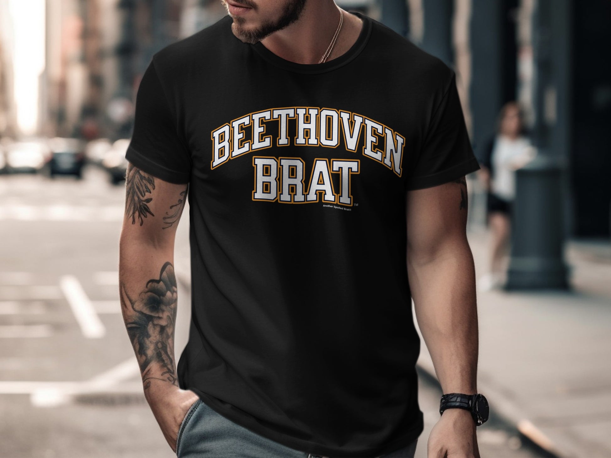 Black t-shirt with "BEETHOVEN BRAT" text in yellow and white varsity lettering.