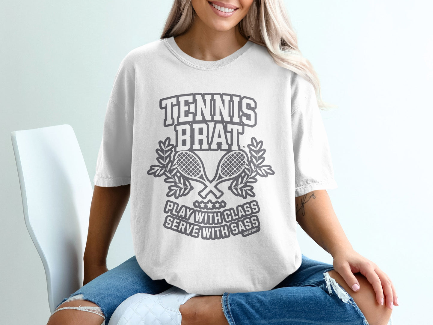 White t-shirt with "TENNIS BRAT" and crossed rackets graphic.