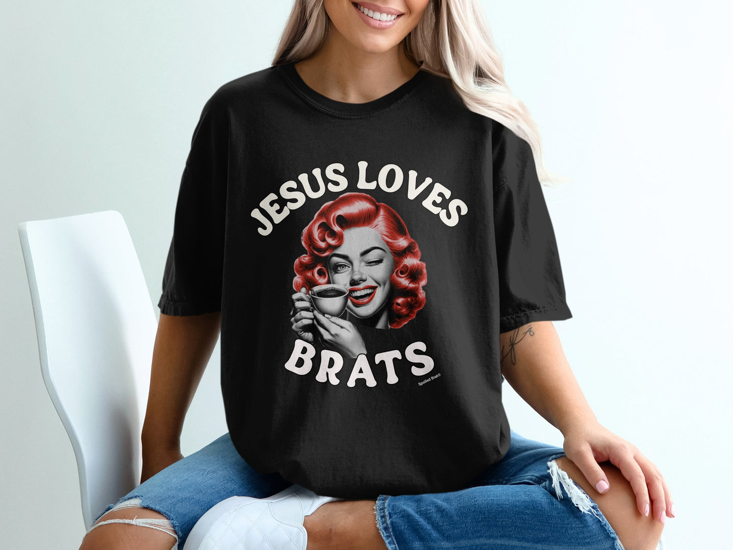 Black t-shirt with retro woman winking and text "JESUS LOVES BRATS".