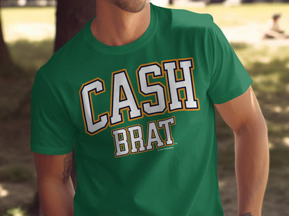 Green t-shirt with white "CASH BRAT" text outlined in yellow and navy.