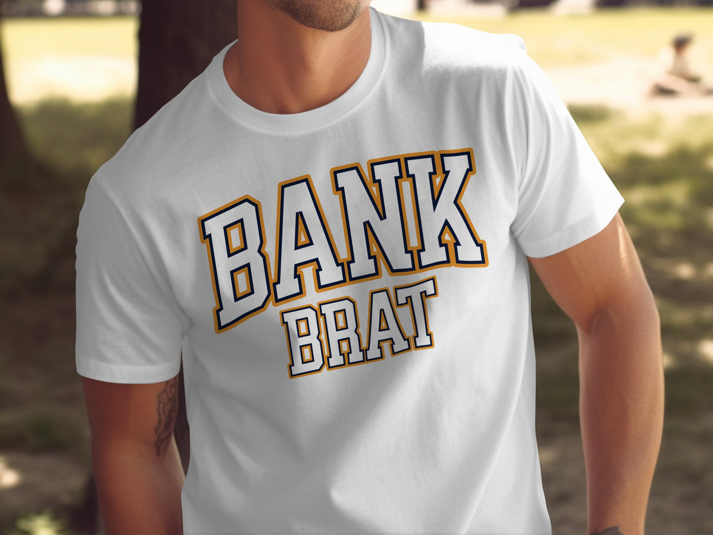 White t-shirt with navy and gold text reading "BANK BRAT"
