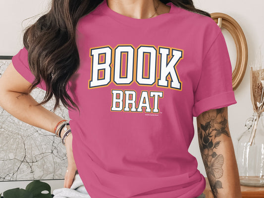 Pink t-shirt with "BOOK BRAT" in collegiate style lettering.