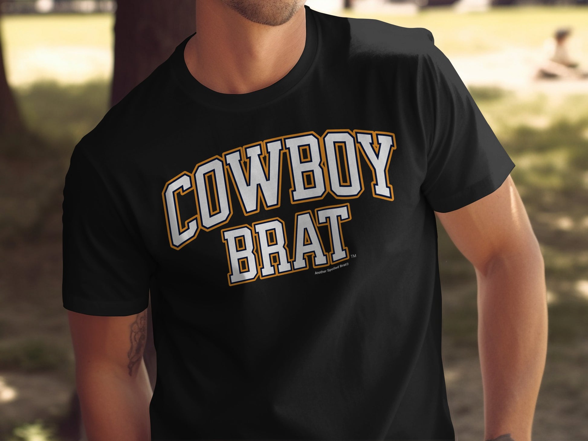 Black t-shirt with white and orange "Cowboy Brat" text and small text under it.