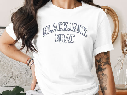 White t-shirt with "BLACKJACK BRAT" text in navy collegiate font.