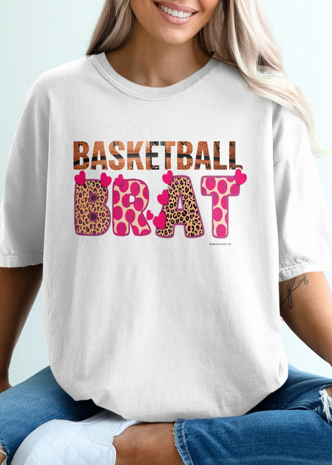 White t-shirt with "BASKETBALL BRAT" text in leopard print and heart designs.